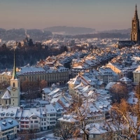 A snowy cityscape with historic buildings and a large church in the background.