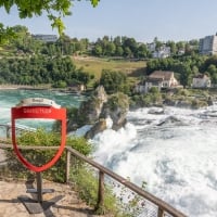 A view of the Rhine Falls with a "Grand Tour of Switzerland" sign in the foreground.