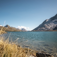 Eine ruhige Berglandschaft mit klarem See und blauem Himmel.