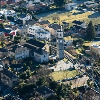 Aerial view of a village with historic buildings and a tall church tower.