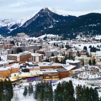 A snowy cityscape with mountains in the background.