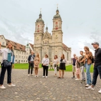 Gruppo in visita guidata davanti a una chiesa storica.