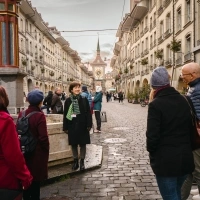 A tour guide is speaking to a group in Bern’s Old Town, with the Zytglogge clock tower visible in the background.