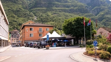 Un beau paysage de montagne avec un hôtel au premier plan et plusieurs voitures sur le parking.