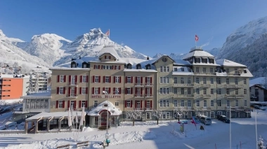 Hotel in the snow with mountains in the background.