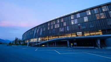 Modern building facade with glass front at sunset.