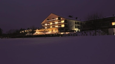 Ein beleuchtetes Gebäude im Schnee bei Nacht.