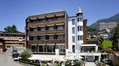 Hotel building on a street with restaurant and parasols
