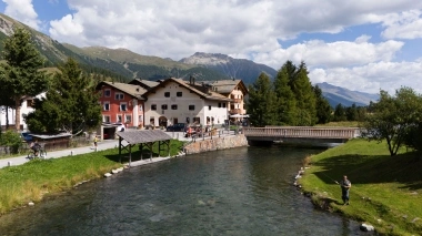 River with a wooden bridge and mountains in the background