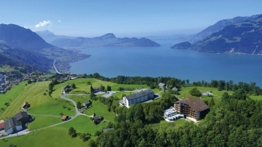 Green meadows and a large lake with mountains in the background