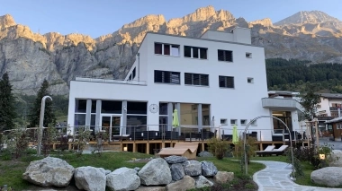 Mondernes Gebäude mit Garten und Bergen im Hintergrund