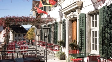 Terrace with tables and chairs in front of a hotel