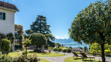 Schöner Garten mit Liegestühlen und Blick auf den See