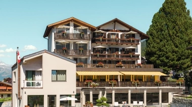 Hotelgebäude mit Garten und einem grossen Baum