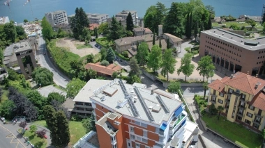 Luftaufnahme vom Hotel mit See und Bäumen im Hintergrund