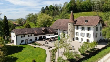 Luftaufnahme vom Hotel mit Garten bei sonnigem Wetter