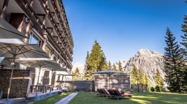 Jardin idyllique de l'hôtel avec les montagnes en arrière-plan