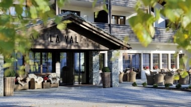 Entrée de l'hôtel en bois, bordée d'arbres