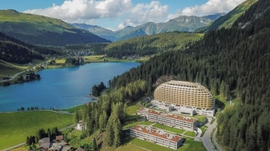 Luftaufnahme vom Hotel mit See, Bergen und Wälder im Hintergrund