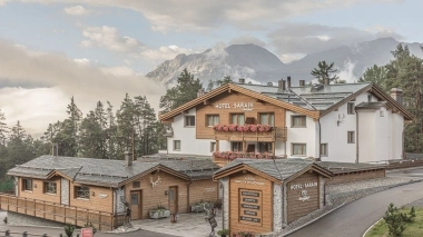 Aussenansicht vom Hotel mit Bergen im Hintergrund bei morgendlicher Stimmung mit Nebel