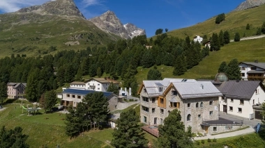 Vue aérienne de l'hôtel, entouré d'arbres et avec les montagnes en arrière-plan