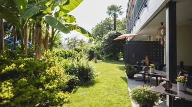 Mediterranean front garden with palm trees and a fully furnished terrace.