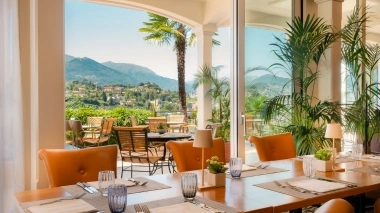 Restaurant mit gedecktem Tisch, welches auf eine Terrasse und mediterrane blickt.