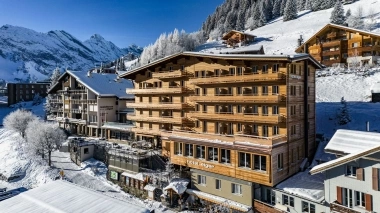 Vista esterna invernale dell'hotel in stile chalet con il bel tempo.