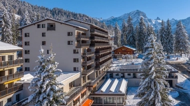 Exterior view of the hotel with a view of the peaks.