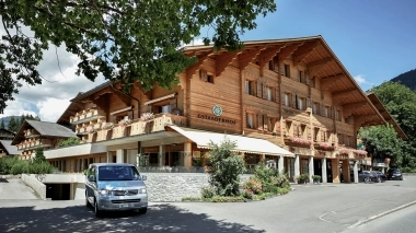 Aussenansicht vom Hotel im Chaletstil und Blumen im Vordergrund
