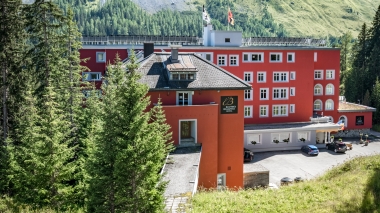 Das Hotelgebäude von aussen, umgeben von majestätischen Pinien.