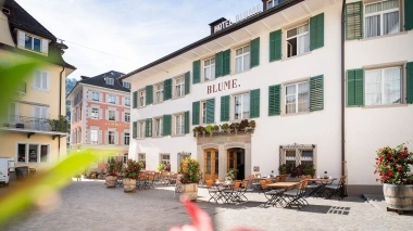 Ingresso dell'hotel con tavoli nell'area esterna.