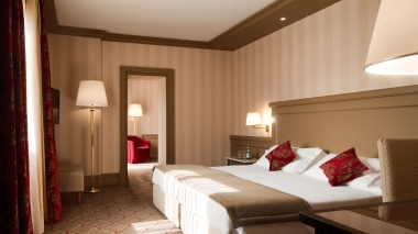 Camere d'albergo dai colori neutri con tocchi di rosso.