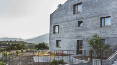 Ein mit Holzfassade vor einer Hügeligen Landschaft.