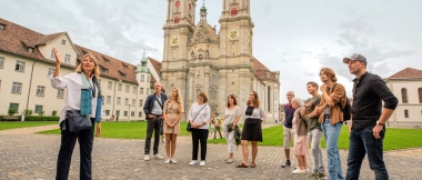 Gruppe beim Stadtrundgang vor einer historischen Kirche.