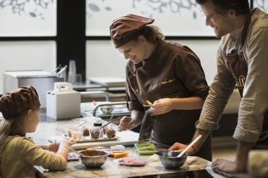 A woman, a man, and a child are preparing food together in a kitchen.