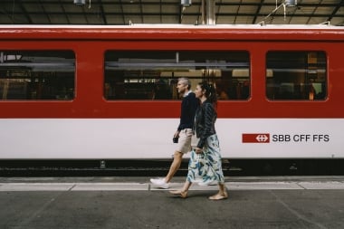 Zwei Personen gehen an einem roten SBB-Zug vorbei.