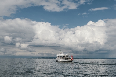 Un bateau sur un grand lac sous un ciel nuageux.