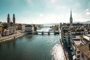 Aerial view of a historic town with river, bridge, and church steeples.