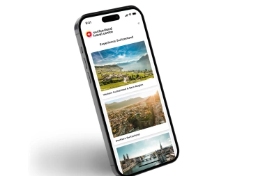Smartphone shows a travel app with pictures of Switzerland.