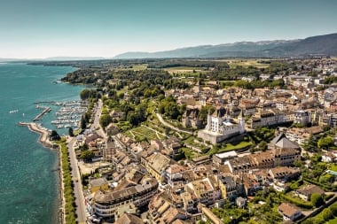 Luftaufnahme von Nyon mit Schloss, Altstadt, Yachthafen und Genfersee