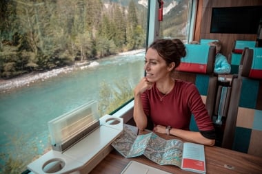 A person sitting in a train, passing a river