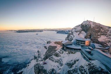 Vue aérienne de l'hôtel au sommet de la montagne au coucher du soleil au-dessus de la mer de brouillard.