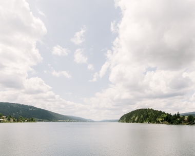 A tranquil lakescape under a partly cloudy sky.