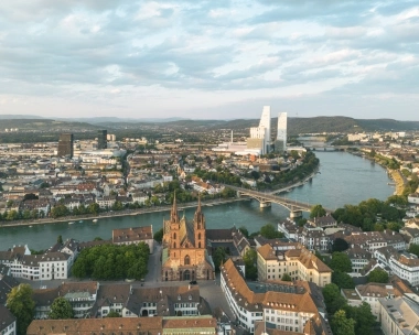 Vue aérienne d'une ville au bord de la rivière avec des ponts et des bâtiments modernes en arrière-plan.