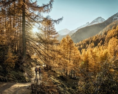 Autumn impressions from Fafleralp in the Lötschental valley. Young couple descending from Grundsee.